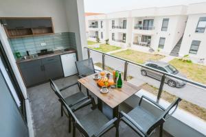 an apartment balcony with a table and chairs and a kitchen at Bumax Apartments in Ulcinj
