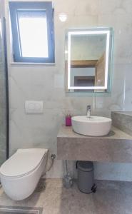 a bathroom with a toilet and a sink and a mirror at Bumax Apartments in Ulcinj +48 photos