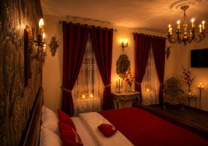 a bedroom with a bed with red sheets and curtains at History Apartments Cetății in Sibiu
