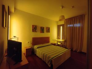 a hotel room with a bed and a television at Margot's House Rho in Rho