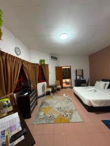 a hotel room with a bed and a living room at Bunga Raya Resort Parit Buntar in Parit Buntar