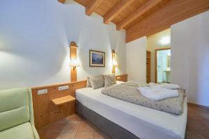 a bedroom with a white bed and a chair at Appartement Hotel Sonneck in Königsleiten +85 photos