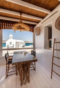 a dining room with a table and chairs and a large window at Captain Zeppos in Pollonia