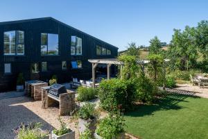 a black house with a garden in front of it at Northside in Kingsbridge
