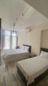 a bedroom with two beds and a chandelier at Toprak otel pansiyon in Akhisar