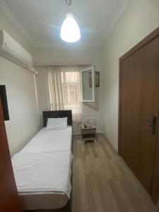 a small bedroom with a bed and a window at Toprak otel pansiyon in Akhisar
