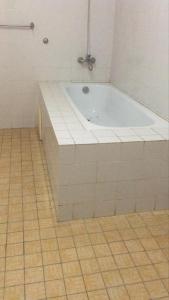 a bath tub in a bathroom with a tiled floor at ESPACE iDIMA 2026 in Djérigbé