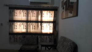 a window with a curtain in a living room at ESPACE iDIMA 2026 in Djérigbé