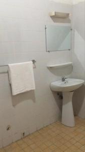 a white bathroom with a sink and a mirror at ESPACE iDIMA 2026 in Djérigbé