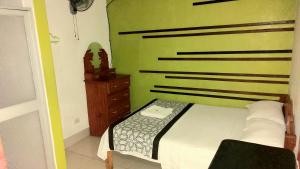 a bedroom with a bed and a wooden dresser at Hospedaje Neydita in Iquitos