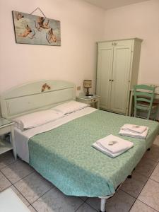 a bedroom with a bed with two towels on it at Hotel Adua in Venice