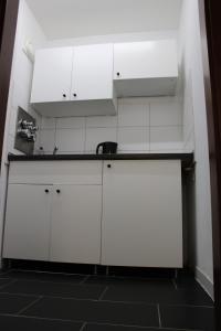 a kitchen with white cabinets and a sink at Messeapartment Köln in Cologne