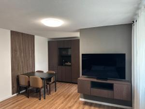 a living room with a table and a flat screen tv at Artha Apartments Rust - Europa-Park in Rust