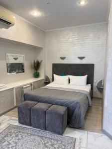 a bedroom with a large bed with two ottomans sidx sidx sidx sidx at Міні-готель RANDEVU in Zhytomyr