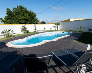 a swimming pool in a yard with chairs and a fence at Casa La Rosa with private pool in Loja de Vendas