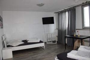 a room with two beds and a table and a television at Messeapartment Köln in Cologne