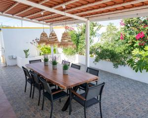 an outdoor patio with a wooden table and chairs at Casa La Rosa with private pool in Loja de Vendas