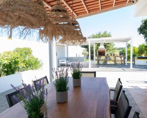 an outdoor dining room with a wooden table and chairs at Casa La Rosa with private pool in Loja de Vendas