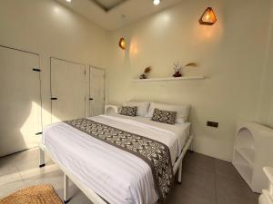 a bedroom with a white bed in a room at Rumah Kodel2 in Bukit Lawang