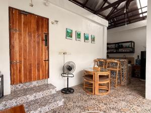 a room with a door and a table and a fan at Rumah Kodel2 in Bukit Lawang