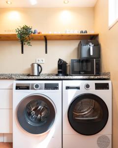a laundry room with two washer and dryer at Casa La Rosa with private pool in Loja de Vendas