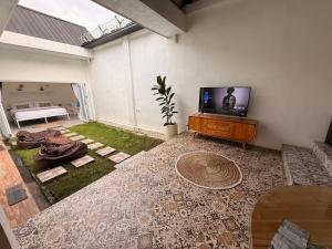 a living room with a flat screen tv on a table at Rumah Kodel2 in Bukit Lawang