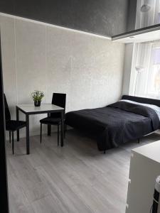 une chambre avec un lit et une table avec des chaises dans l'établissement Apartament MAKEJA, à Malbork