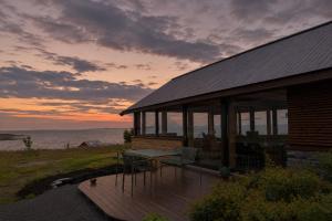 a house with a table and chairs on a deck at Storøya Lodge Lofoten in Vestvågøya