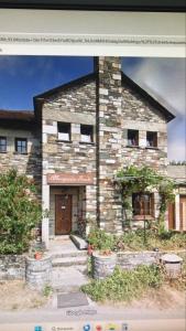 a stone building with a door in front of it at Albergueria Frade in O Cebrero