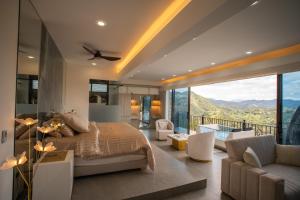 a bedroom with a bed and a balcony with mountains at La Colina Resort SAS in La Vega