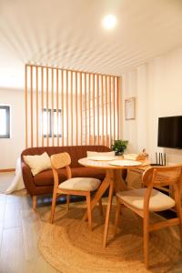 a living room with a couch and a table and chairs at VIELA Guest House Premium in Barcelos