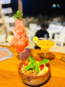 two cocktails and a bowl of food on a table at Golden Beach Cottages in Trincomalee