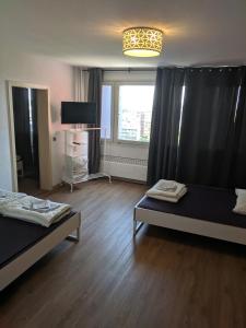 a living room with two beds and a window at Messeapartment Köln in Cologne +48 photos