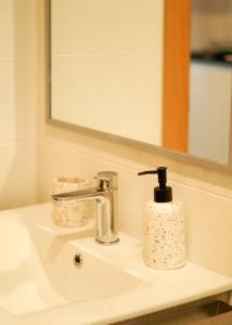 a bathroom sink with a soap dispenser on it at VIELA Guest House Premium in Barcelos +28 photos