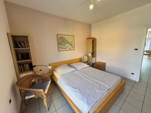 a bedroom with a bed and a chair in it at Lago Blu in Riva del Garda