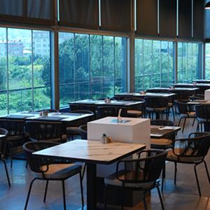an empty classroom with tables and chairs and windows at Aloft by Marriott Bursa Hotel in Bursa