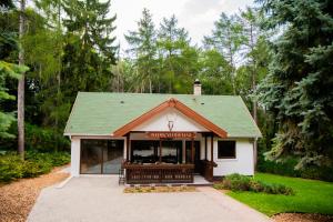 a shop with a green roof in a park at Nedecvidék ház in Isztimér