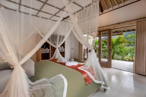 a bedroom with a green bed with mosquito nets at ArtVilla Sidemen River in Sidemen