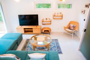 a living room with a blue couch and a tv at Nedecvidék ház in Isztimér