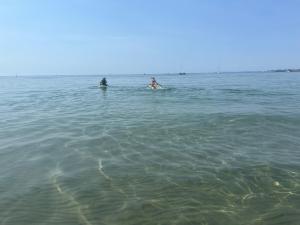 two people swimming in the water in the ocean at Krageholmshytten in Karrebæksminde