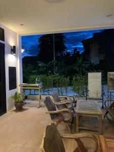 a patio with chairs and a table and a large window at Wangta in Haad Rin