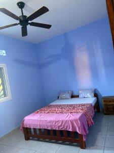 a bedroom with a bed with a ceiling fan at Villa Donia Nosy be in Nosy Be