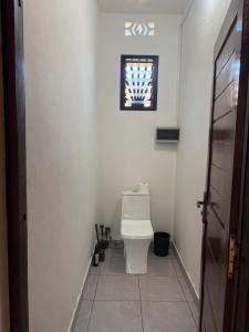 a white bathroom with a toilet and a window at Villa Donia Nosy be in Nosy Be