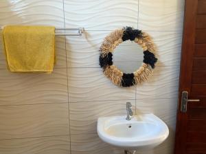 a bathroom with a wreath on the wall and a sink at Villa Donia Nosy be in Nosy Be