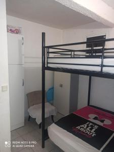 a bedroom with two bunk beds and a chair at F2 F3 Marjo tranquillity in Le Carbet