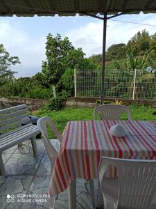 a table and chairs with a table and an umbrella at F2 F3 Marjo tranquillity in Le Carbet