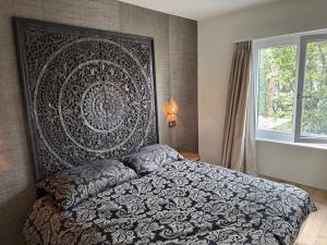 a bedroom with a bed with a large headboard at Ascona Casa Mamina A in Ascona