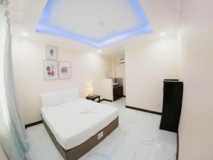a white bedroom with a bed and a blue ceiling at Balud White Beach Resort in Moalboal