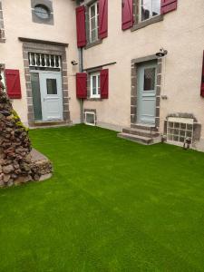 a house with a green lawn in front of it at La Lit'Hote in Mirefleurs
