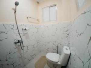 a white bathroom with a toilet and a window at Balud White Beach Resort in Moalboal